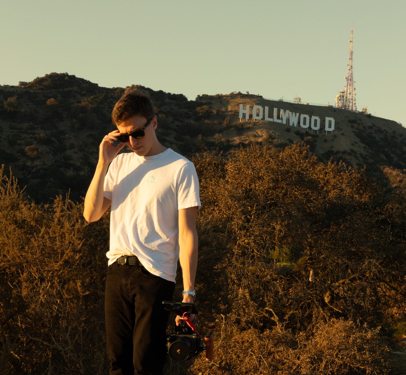 Christopher Spring with a camera below the Hollywood sign